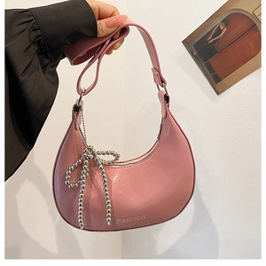 Detail of pink PU leather handbag with silver beaded bow charm and Fashion logo
