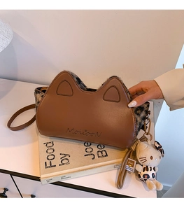 Détail d'un sac bandoulière en cuir marron avec oreilles de chat et bordure en léopard