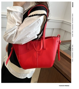 Close-up of red lychee pattern tote bag with white stitching and side knot detail