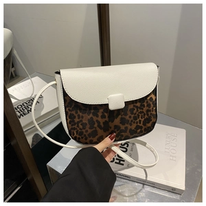 Detail of crossbody bag featuring white litchi leather and leopard print pattern contrast