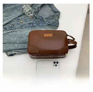 Macro shot of brown leather storage bag with contrast stitching and rectangle patch logo