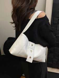 Minimalist white rivet hobo bag with gold metal rings shown on a model's shoulder