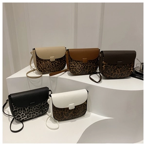 Detail of crossbody saddle bags featuring leopard print patchwork and lychee texture