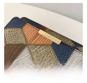 Detailed close-up of textured patchwork leather with crocodile patterns and gold buckle