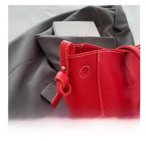 Close-up of red lychee pattern leather tote with exquisite white stitching details