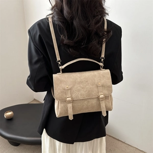 Detail of vintage apricot PU leather backpack with magnetic flap and metal buckle straps