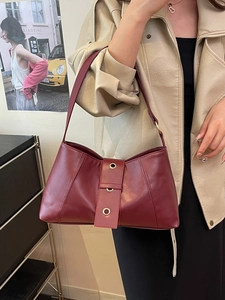 Vintage wine red shoulder bag with rivet accents and wide strap for elegant commuting