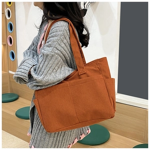 Detail of caramel corduroy tote bag showing ribbed texture and side pocket design