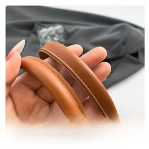 Detail of ergonomic brown leather handles with precise stitching on leopard tote bag