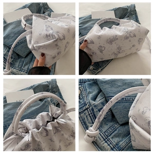 Detalles del bolso de mano blanco con estampado de mariposa y asa anudada suave