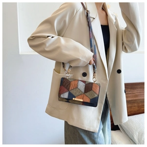 Detail of vintage patchwork crossbody bag with colorful geometric patterns and gold buckle