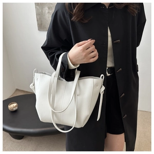 Detail of white litchi pattern tote bag showing textured material and dual handle design