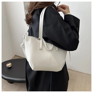 Detailed view of white litchi pattern leather tote bag with elegant side tie decoration