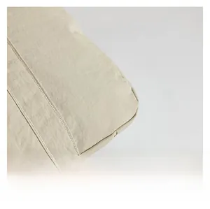 Detail view of khaki nylon fabric showing durable double-stitched seams and soft texture