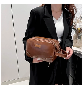 Brown vintage faux leather toiletry bag with three zipper layers and a side hand strap