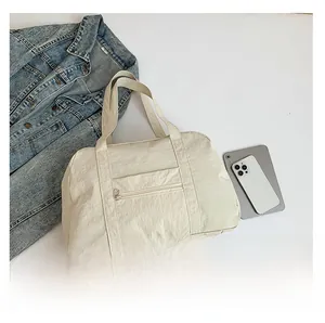 Detailed top view of a cream nylon travel bag with a durable zipper pocket and straps
