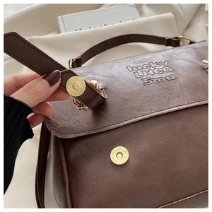 Detail of brown vintage PU leather texture with magnetic closure and embossed logo