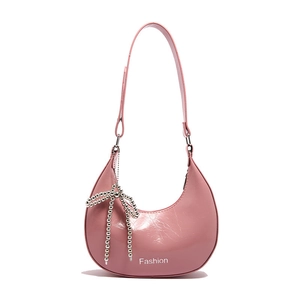 Pink crescent underarm bag with glossy finish and silver beaded bow charm pendant