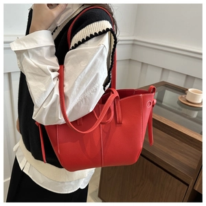 Detail of red lychee textured tote bag with white contrast stitching and spacious design