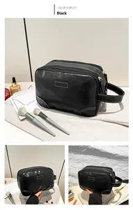 Detail of black multi-layer PU leather toiletry bag with quilted stitching and handle