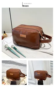 Brown PU leather travel toiletry bag with three compartments and side handle detail
