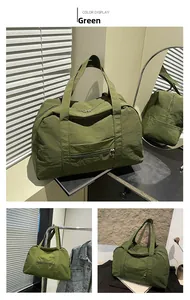 Detail view of a green nylon travel tote bag with zipper pocket and dual handles