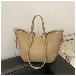 Detailed macro view of beige lychee texture tote with dual handles and side drawstring