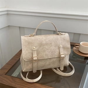 Close-up of retro cream textured leather backpack with metal buckles and handle
