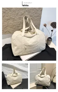 Detailed view of a white crinkled nylon travel tote featuring sturdy handles and front pocket