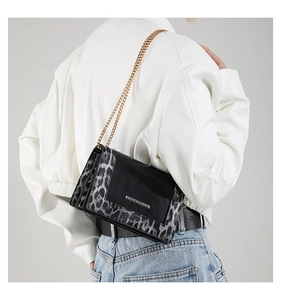 Detail view of stylish leopard print shoulder bag with gold chain and flap design