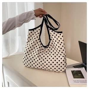 Detailed close-up of large capacity polka dot canvas tote bag in a lifestyle setting