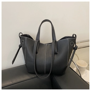 Detail of black lychee grain leather tote bag with stylish white contrast stitching