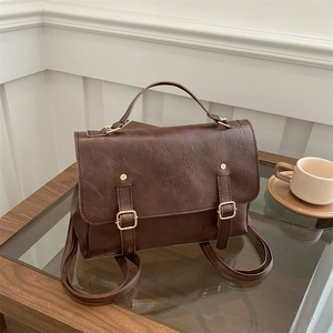 Detail view of vintage brown leather backpack with Lucky LHCO embossed logo and metal buckles