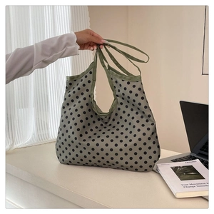Detail view of large polka dot tote bag in grey-green fabric with black spots