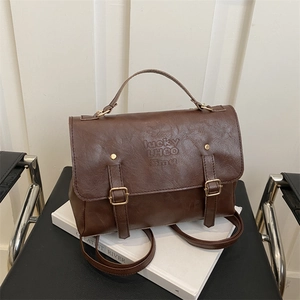 Detailed close-up of dark brown vintage leather backpack with twin straps and lucky embossing