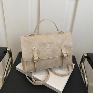 Detail of cream PU leather backpack with vintage texture and decorative buckle straps