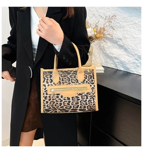 Detail of leopard print tote bag with brown handles and stylish metal zipper pocket