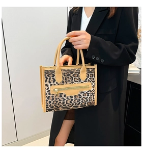 Detail of leopard print tote bag with camel leather trim and golden zipper pocket