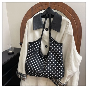 Detail shot of large capacity black canvas tote bag with white polka dots for daily use
