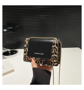 Detailed macro view of leopard print chain bag with gold hardware and matte flap