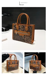 Detail view of leopard print tote bag with brown handles and a functional front zipper pocket