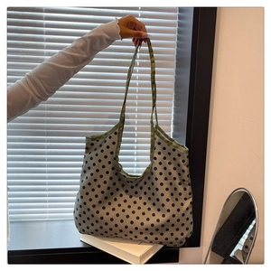 Detail of greyish-green polka dot canvas tote bag showing the soft texture and long handles