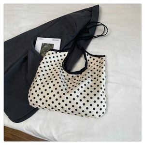 Polka dot canvas tote bag detail showing black dots on cream fabric with black trim