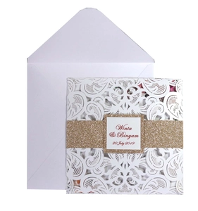 Elegant white laser-cut wedding invitation with gold glitter band and paisley pattern