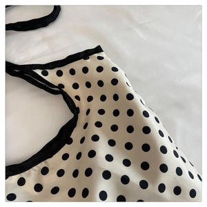 Detailed close-up of polka dot canvas bag fabric showing black ribbon trim and texture