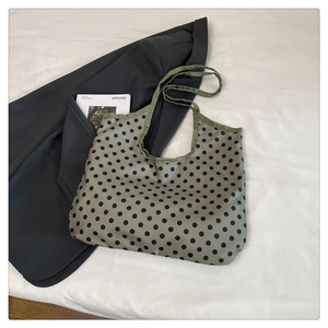 Detailed view of the olive green polka dot tote bag texture and reinforced strap handle