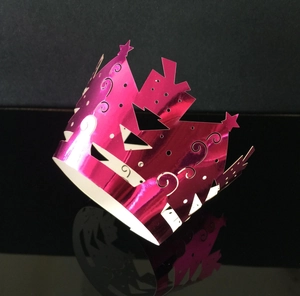 Detail van rose rode metalen cake wrap met ingewikkelde lasergesneden ster- en spiraalpatronen