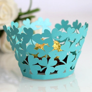 Teal laser-cut heart pattern cupcake wrapper featuring a gold-wrapped chocolate truffle