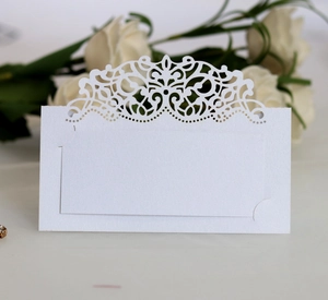 Détail de la dentelle découpée au laser sur un marque-place de mariage en papier nacré