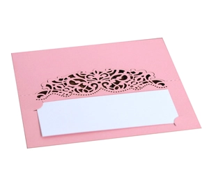 Marque-place de mariage rose découpé au laser avec motifs floraux et insert blanc sur fond blanc